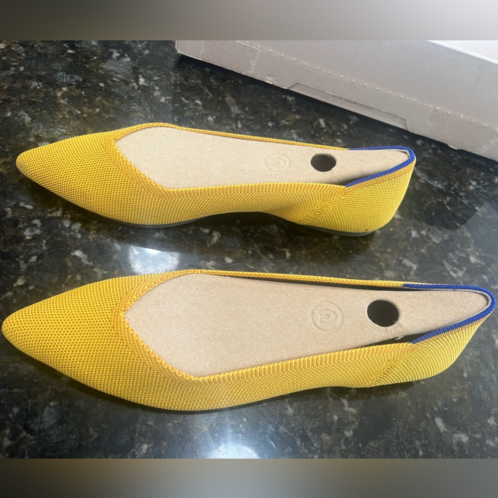 Rothy’s yellow pointed shoes; blue detailing.